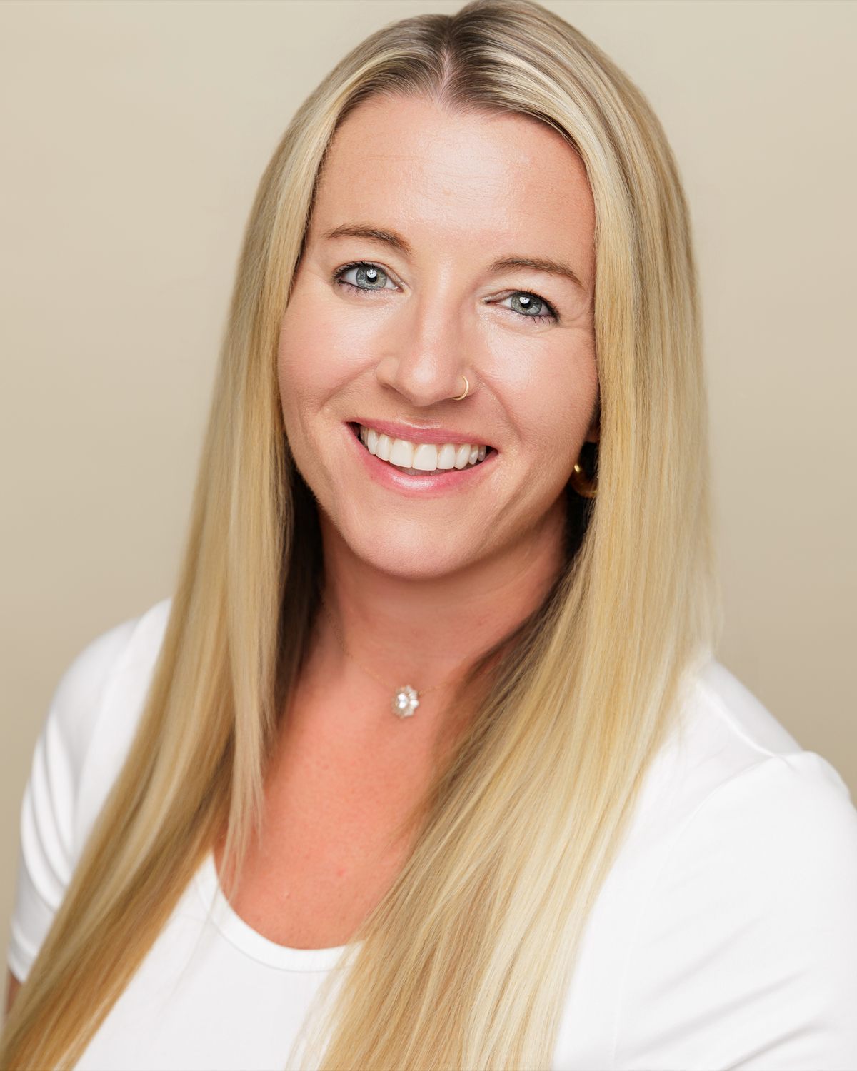 Johnell Huebner, founder of HostWell Consulting and Planning, photographed in a white top against a warm cream backdrop.